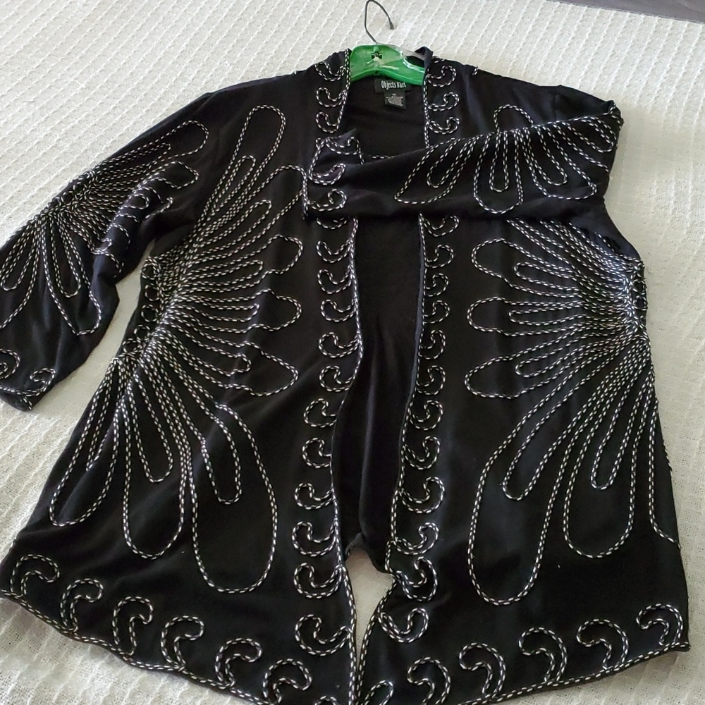 Black and white light weight jacket, sweater, made of material.